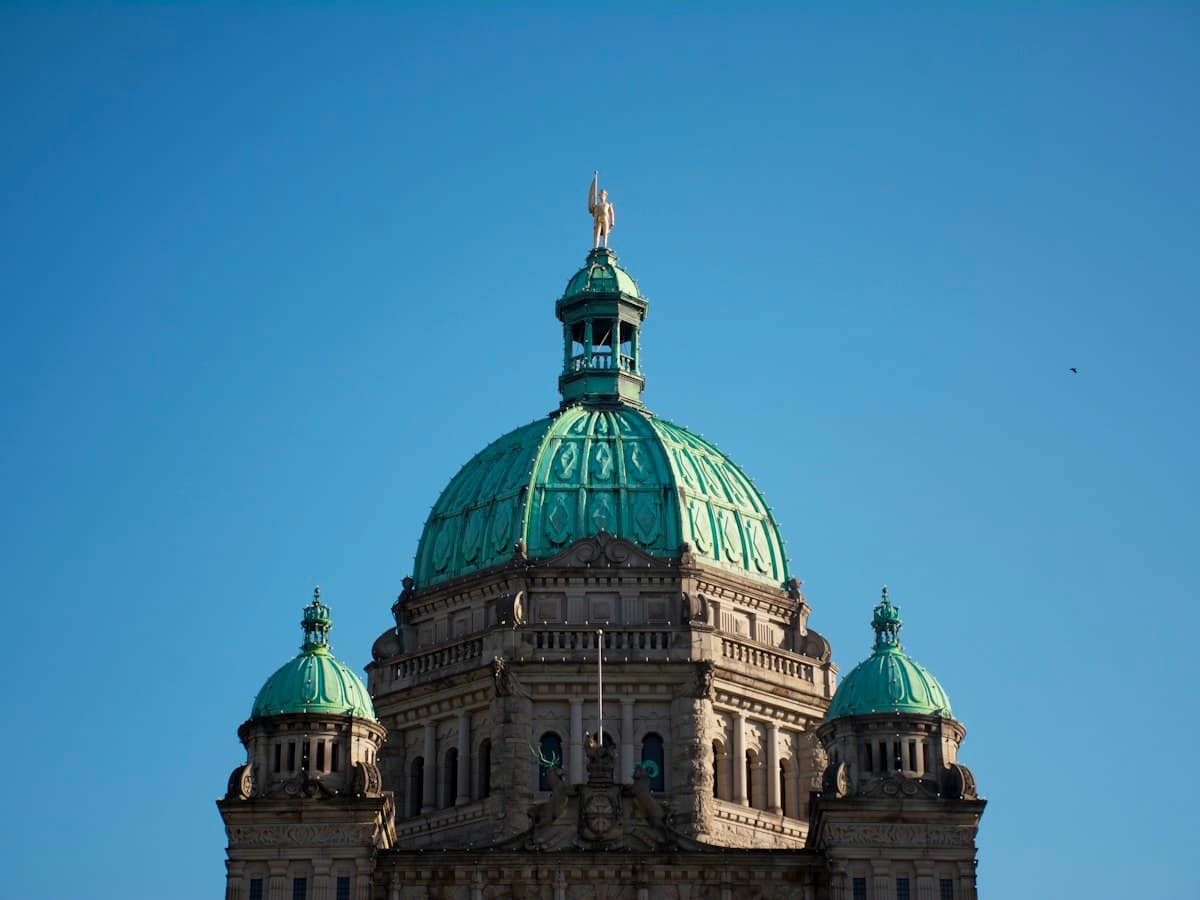 The green dome of a government building against a clear sky